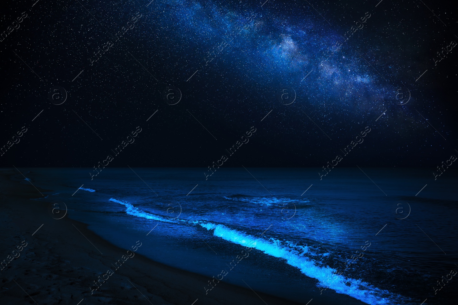 Image of Sea waves rolling onto sandy beach under starry sky at night