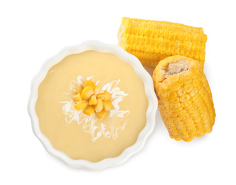 Photo of Delicious corn cream soup and cobs on white background, top view