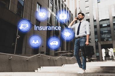 Image of Businessman talking on phone and different icons outdoors. Insurance concept