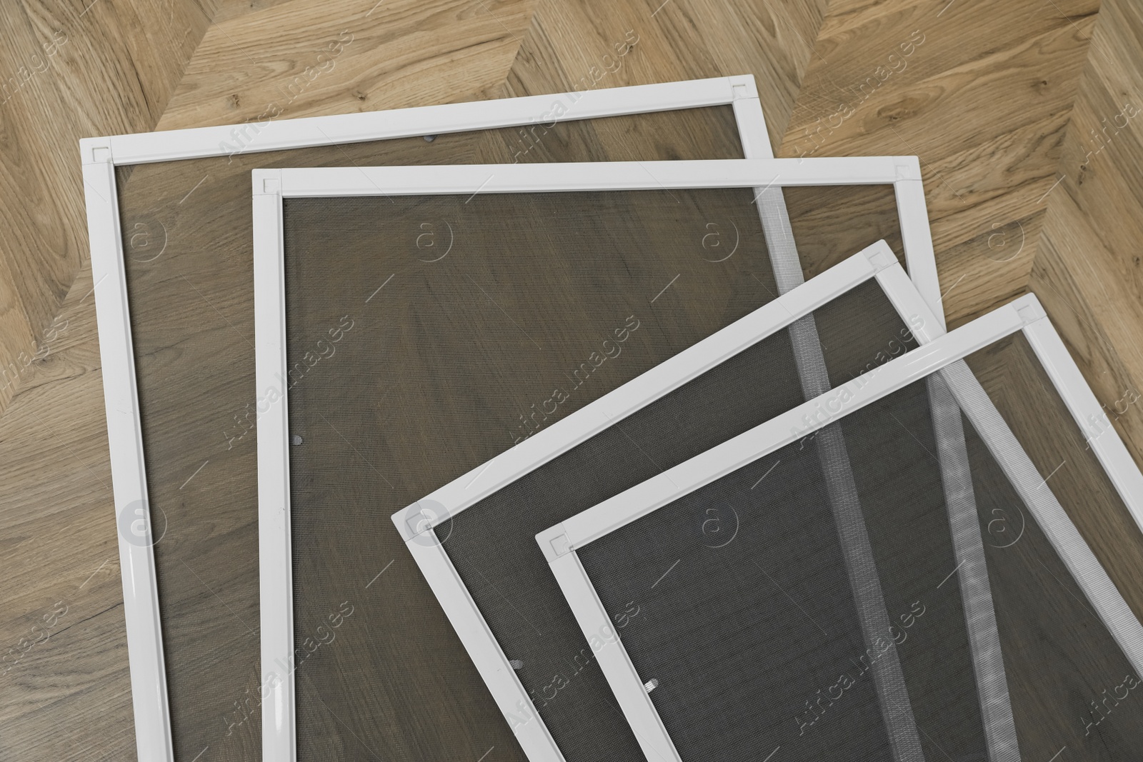 Photo of Set of window screens on wooden floor, flat lay