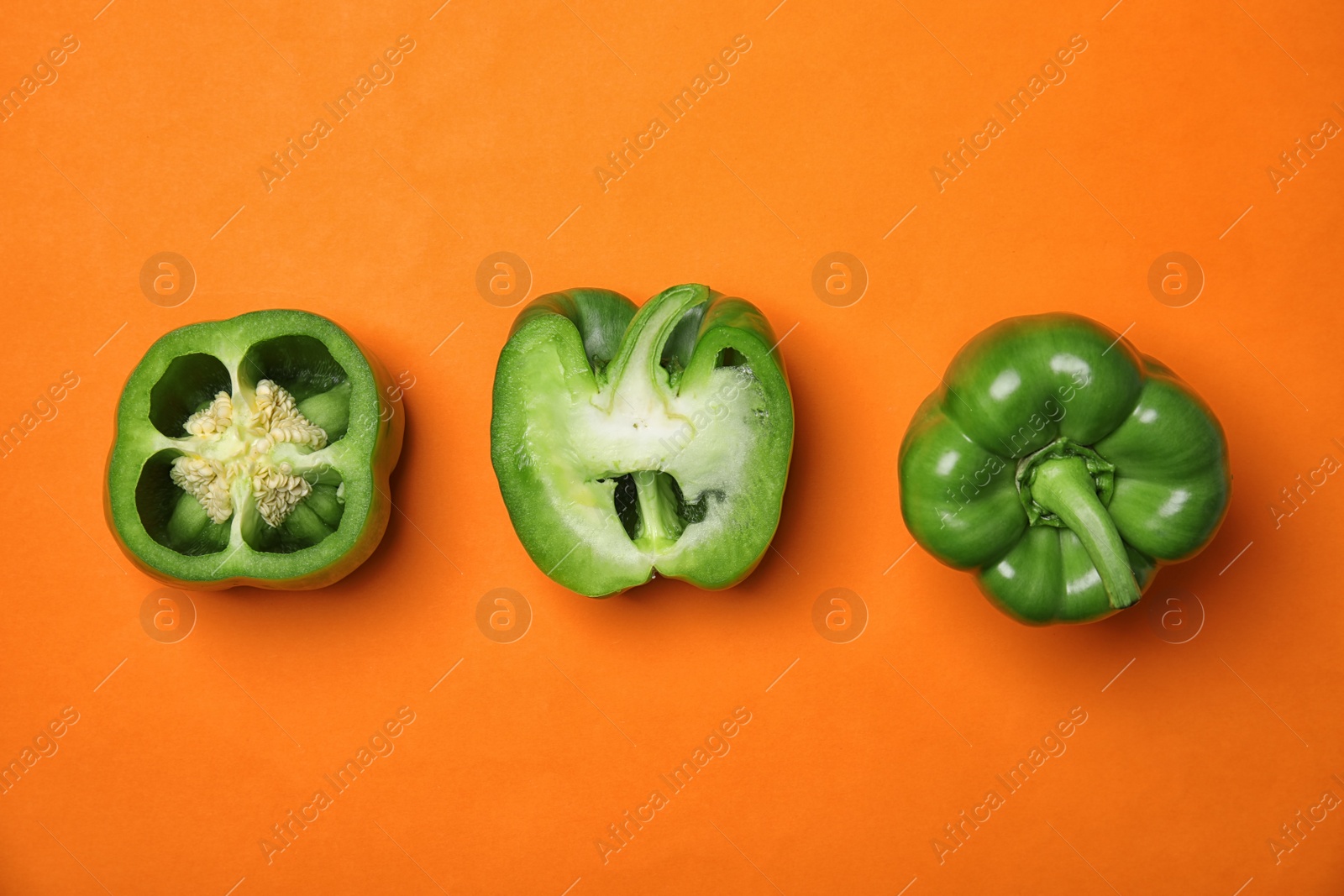 Photo of Cut paprika peppers on color background, top view