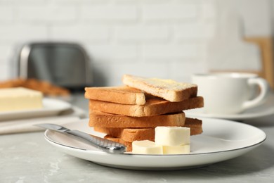 Photo of Tasty toasts with butter served on grey marble table