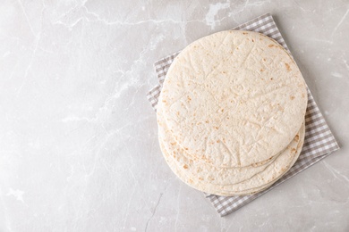 Photo of Corn tortillas on light background, top view with space for text. Unleavened bread