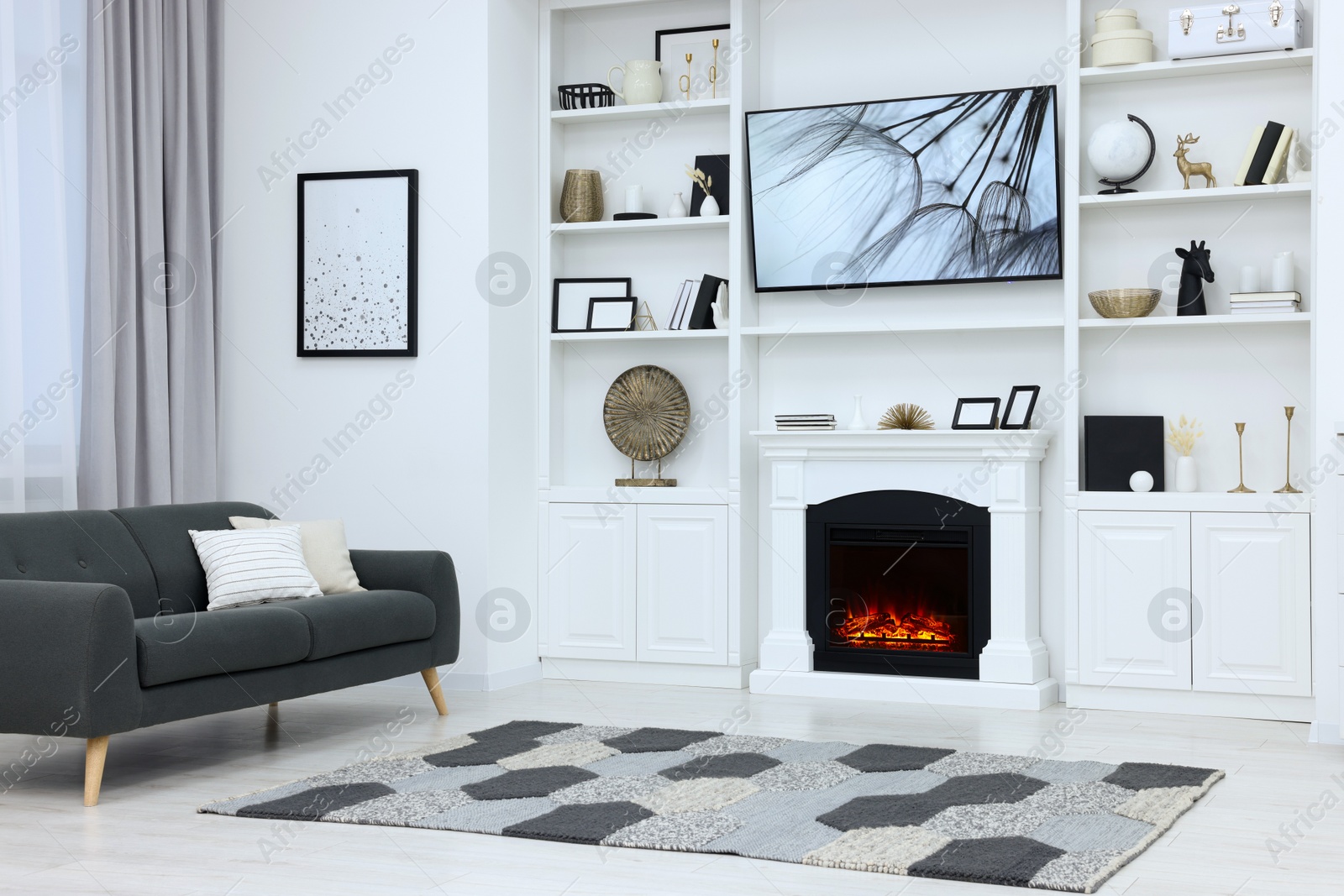 Photo of Stylish room with beautiful fireplace and comfortable sofa. Interior design