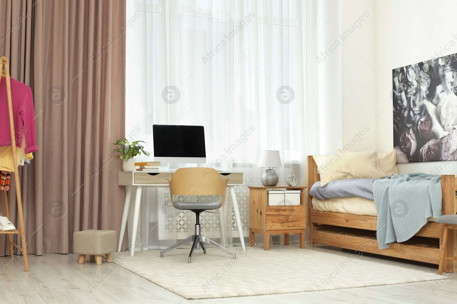 Photo of Stylish teenager's room interior with computer and comfortable bed