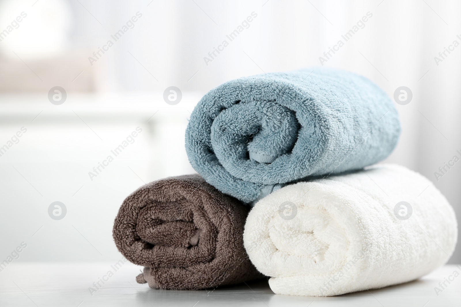 Photo of Pile of fresh rolled towels on table