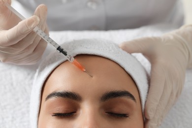 Photo of Doctor giving facial injection to young woman in clinic, closeup. Cosmetic surgery