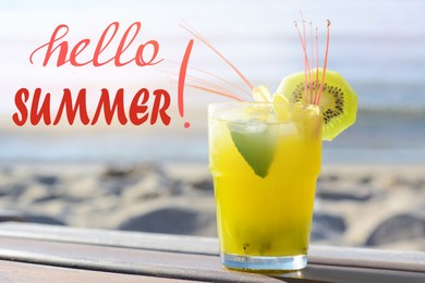 Image of Hello Summer. Glass of cocktail with kiwi on wooden bench near sea