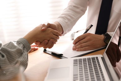 Business people shaking hands in office, closeup