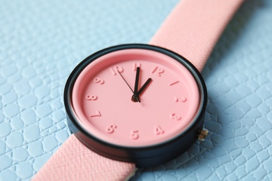 Stylish wrist watch on color background, closeup. Fashion accessory