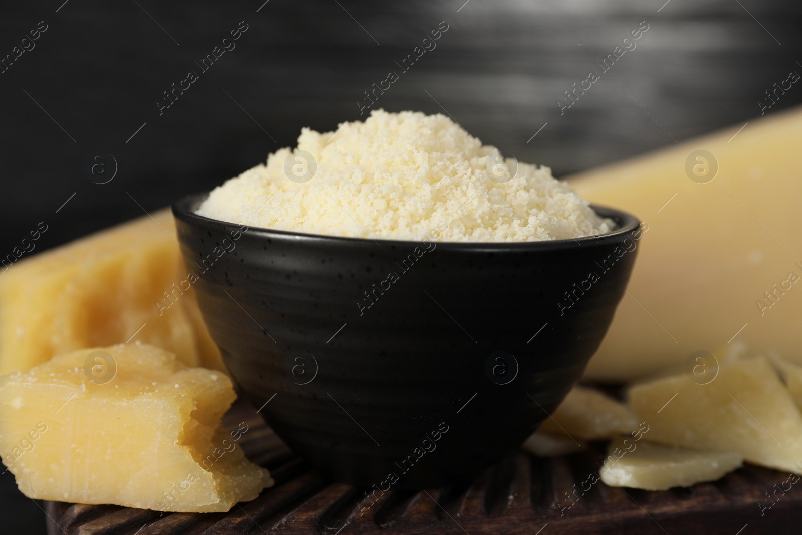 Photo of Bowl with grated parmesan cheese on table, closeup