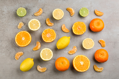 Photo of Flat lay composition with tangerines and different citrus fruits on grey background