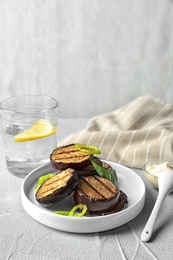 Plate with fried eggplant slices on table