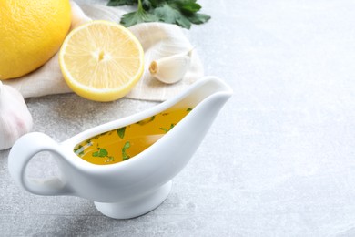 Photo of Ceramic boat with lemon sauce on light table, space for text. Delicious salad dressing