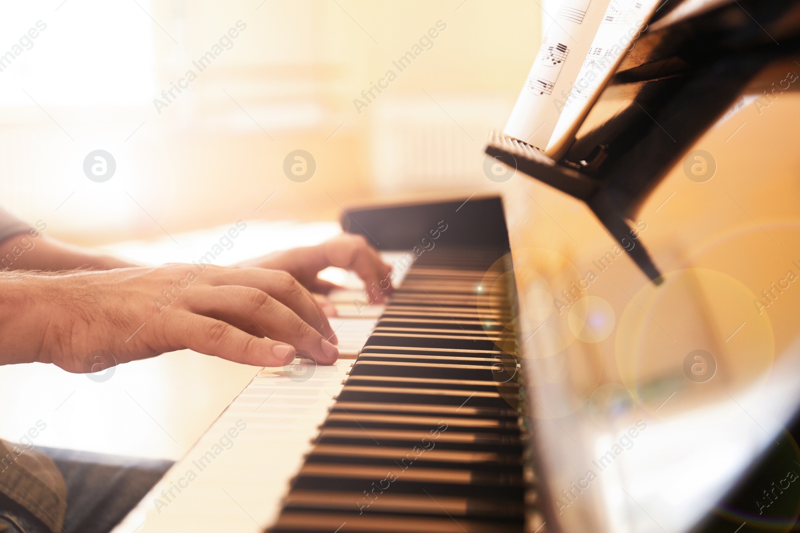 Photo of Man playing piano indoors, closeup. Music lesson