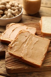 Photo of Tasty peanut butter sandwiches on wooden table, closeup view