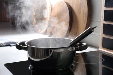 Photo of Steaming pot on electric stove in kitchen