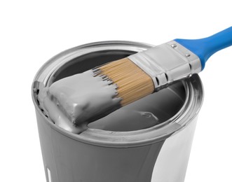 Photo of Can with grey paint and brush on white background, closeup