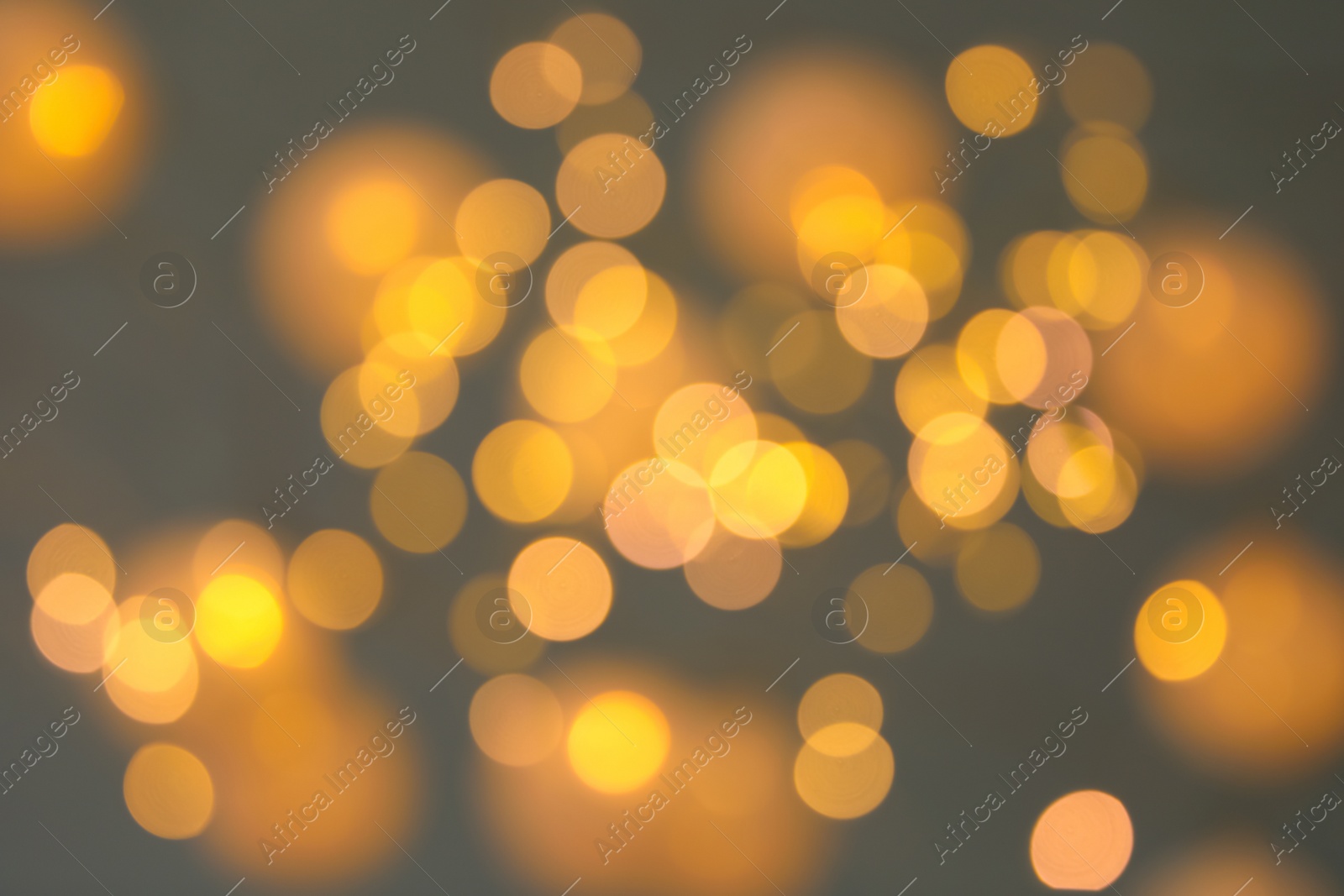 Photo of Blurred view of gold lights on dark background. Bokeh effect