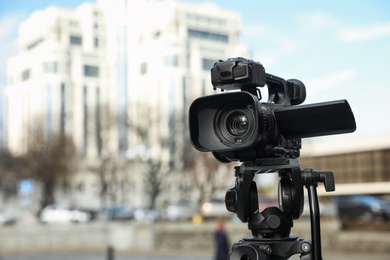 Photo of Professional video camera outdoors. Space for text