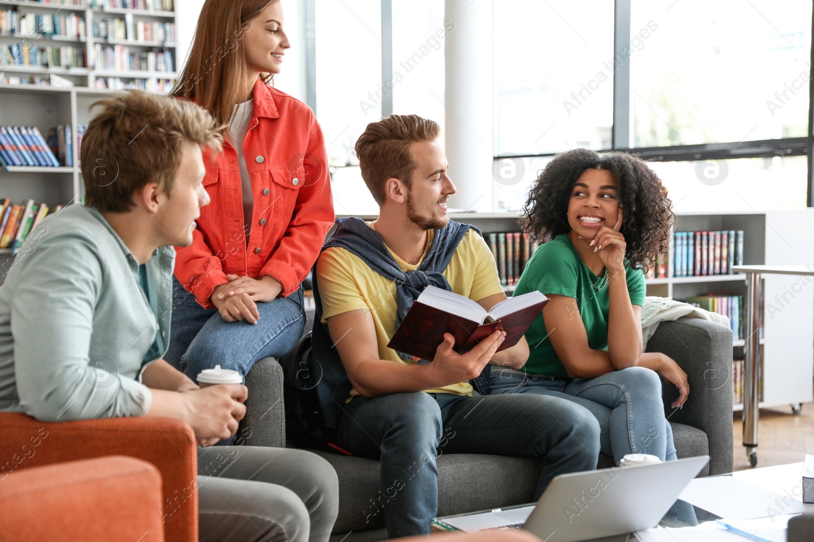 Photo of Group of young people studying at table in library