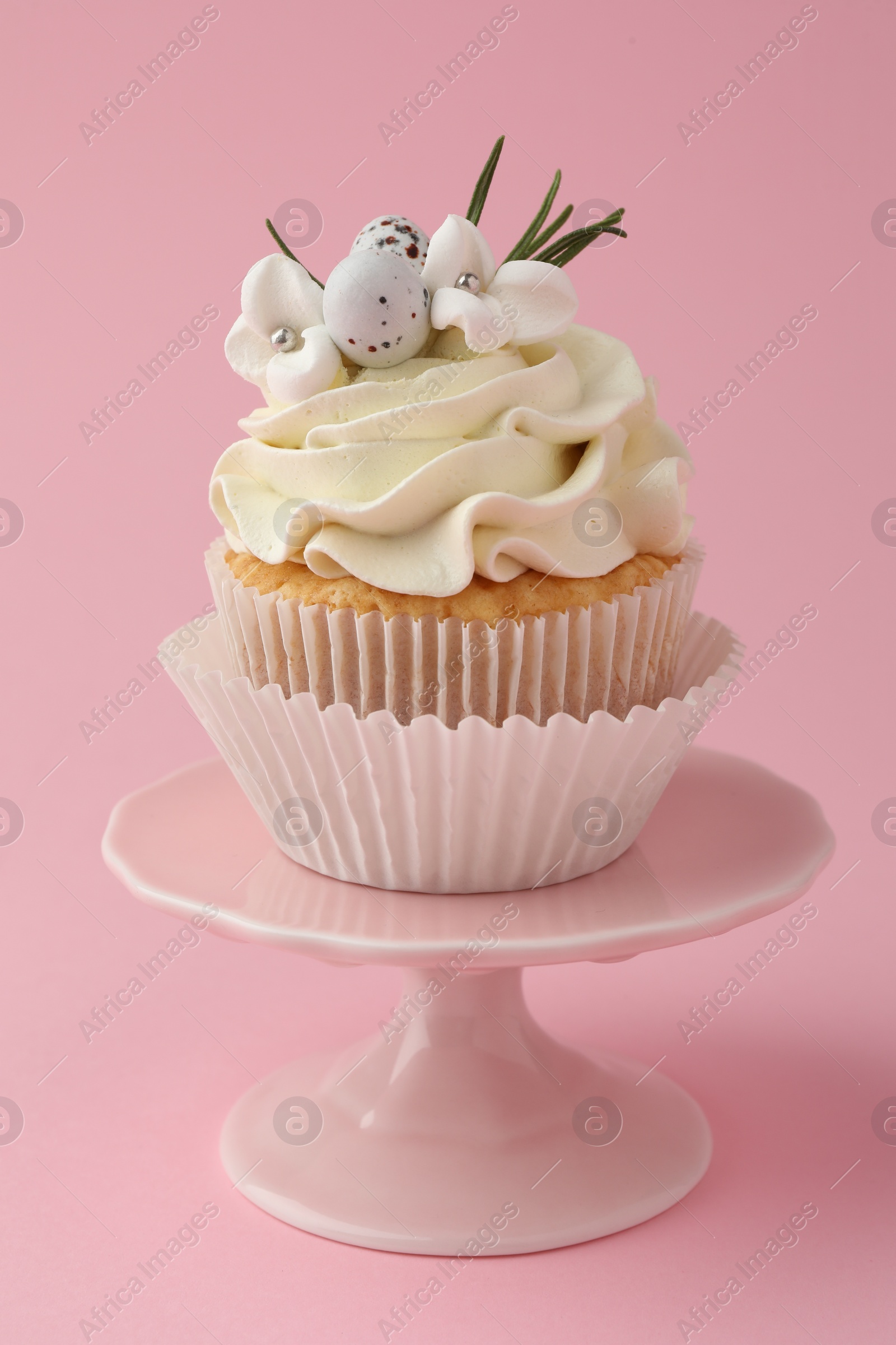 Photo of Tasty Easter cupcake with vanilla cream on pink background