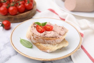 Delicious liverwurst sandwich with tomatoes and basil on white marble table