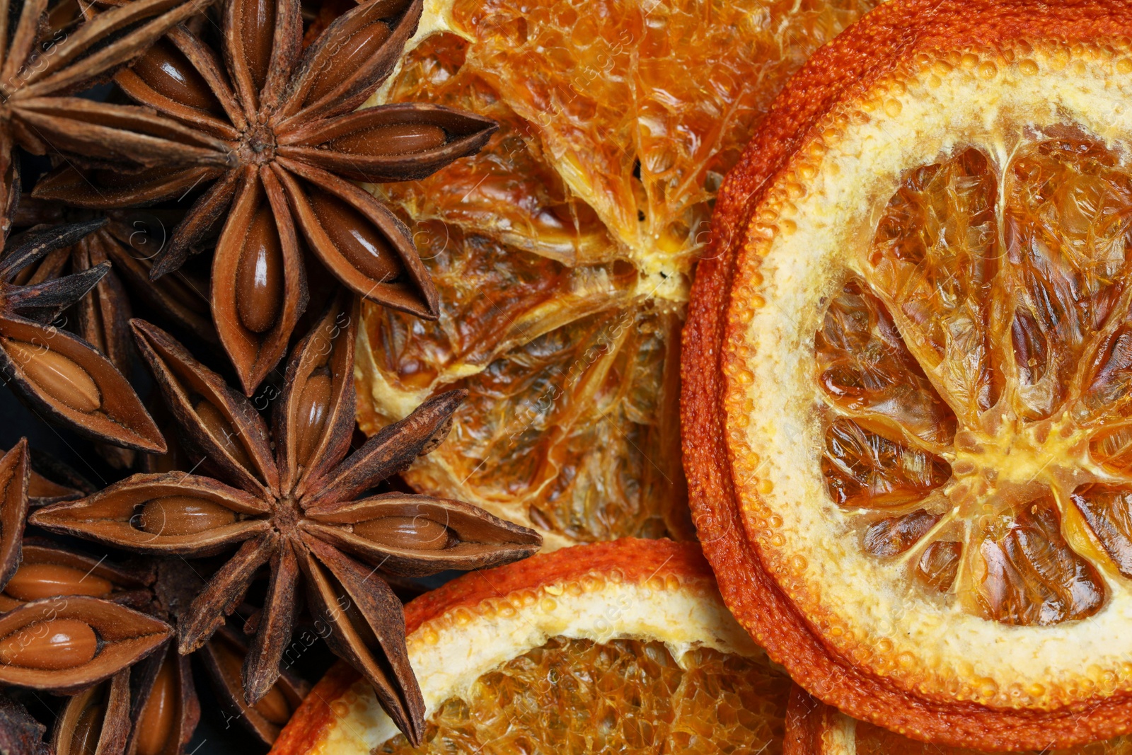 Photo of Dry orange slices and anise stars as background, top view