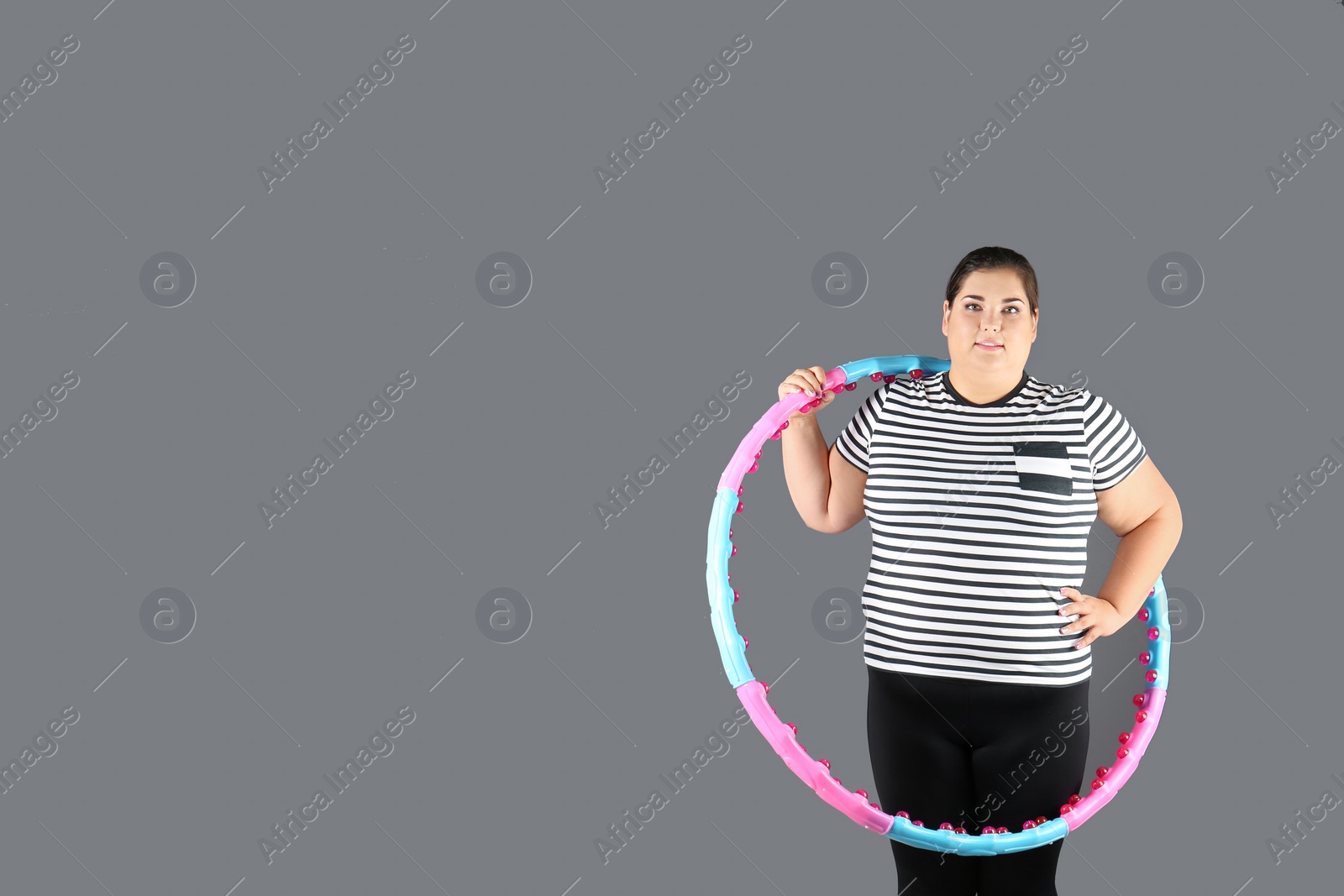 Photo of Overweight woman with hula hoop and space for text on gray background