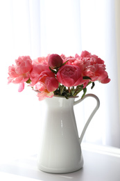 Beautiful bouquet of fragrant peonies in vase on table indoors