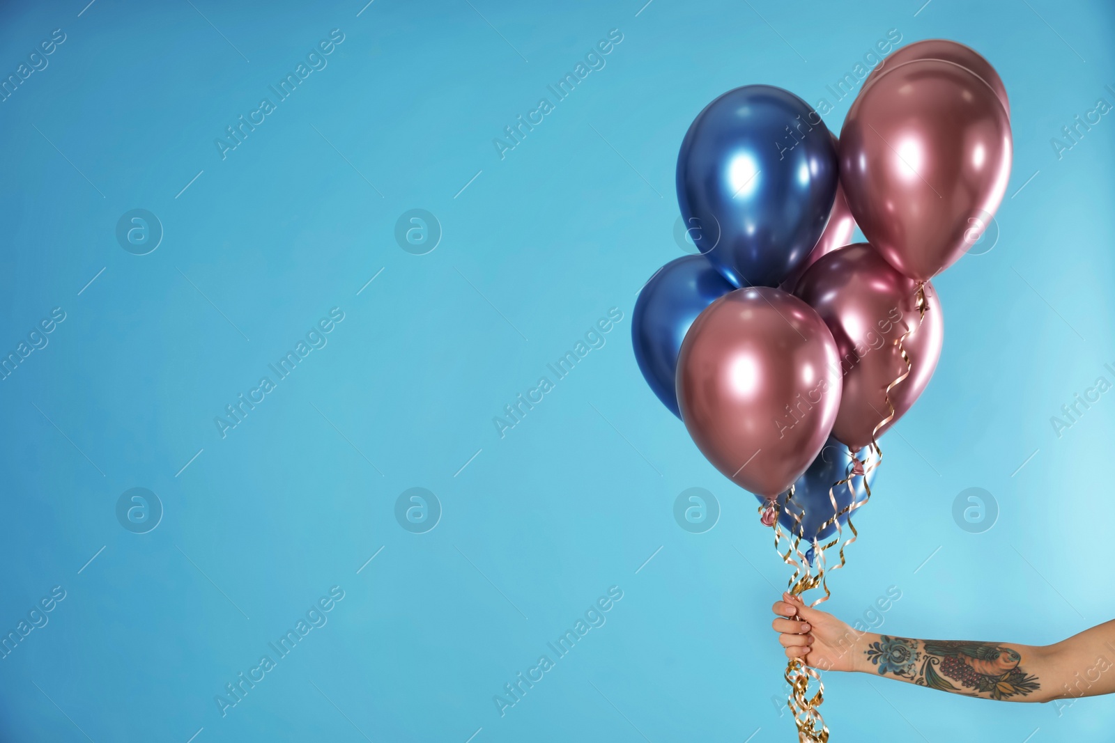 Photo of Woman holding bunch of balloons on color background, closeup. Space for text