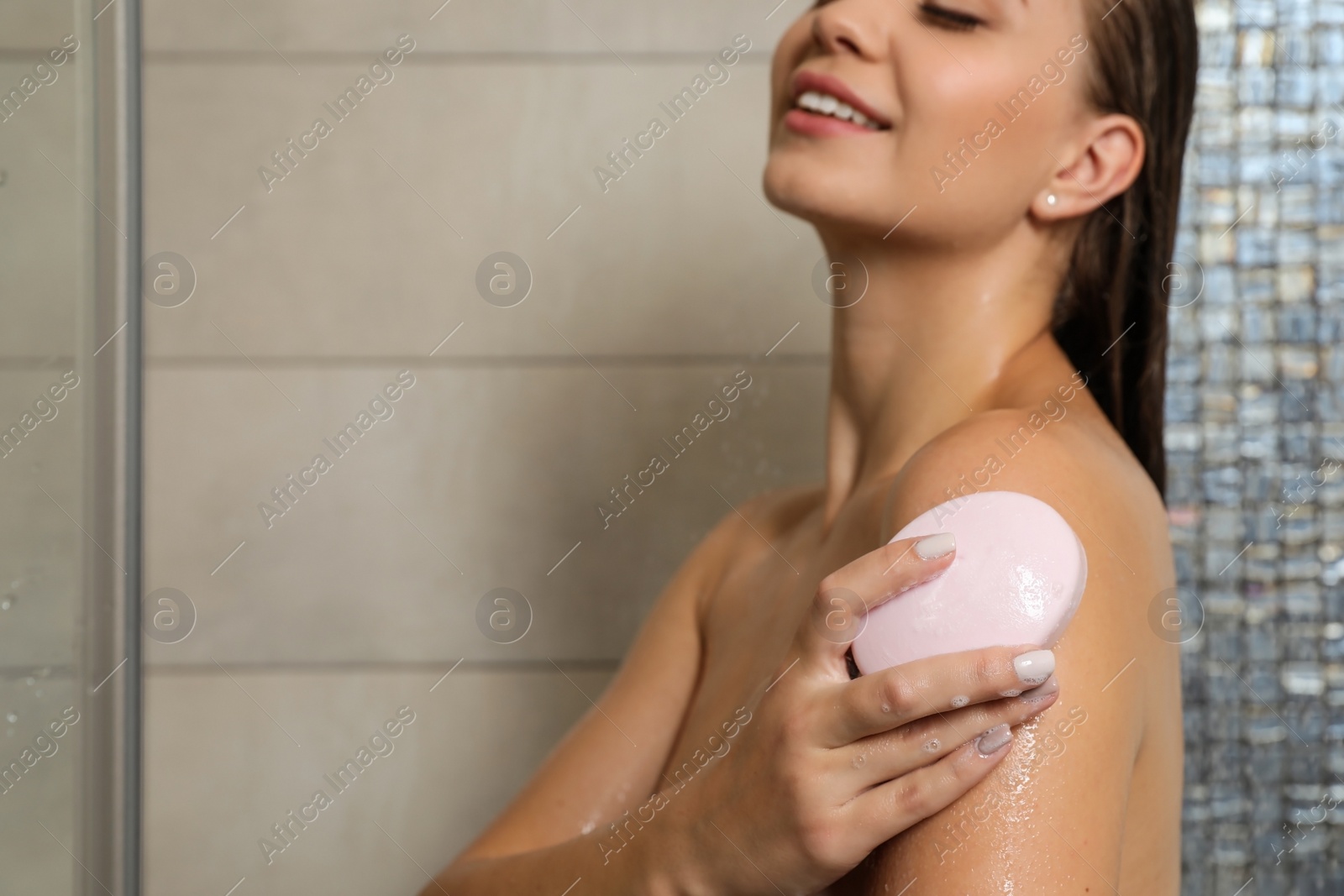 Photo of Beautiful young woman taking shower with soap in bathroom. Space for text