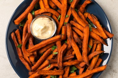 Delicious sweet potato fries served with sauce on light table, closeup