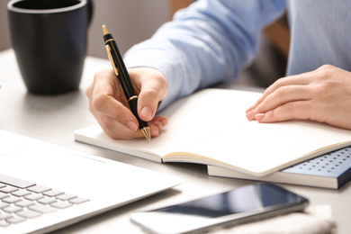 Journalist working at table in office, closeup