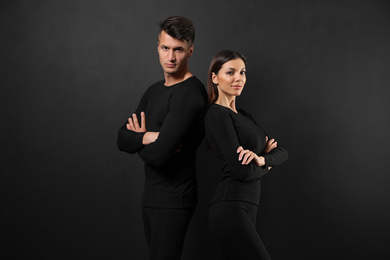 Couple wearing thermal underwear on black background