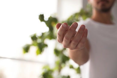 Photo of Man offering helping hand on blurred background, closeup. Space for text