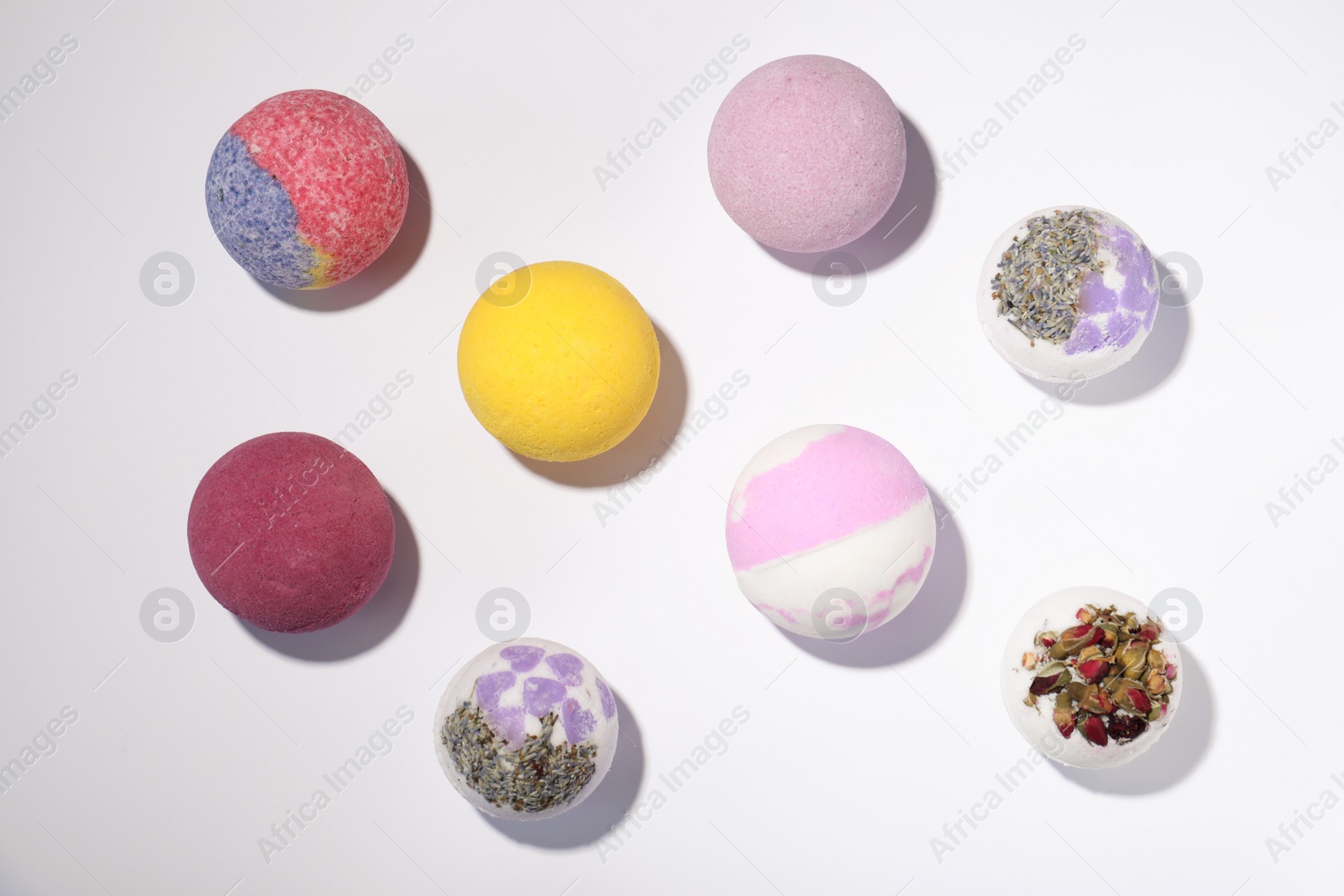 Photo of Colorful bath bombs on white background, flat lay