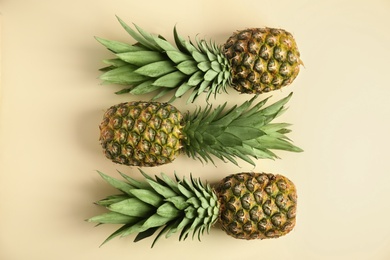 Photo of Fresh ripe juicy pineapples on beige background, flat lay