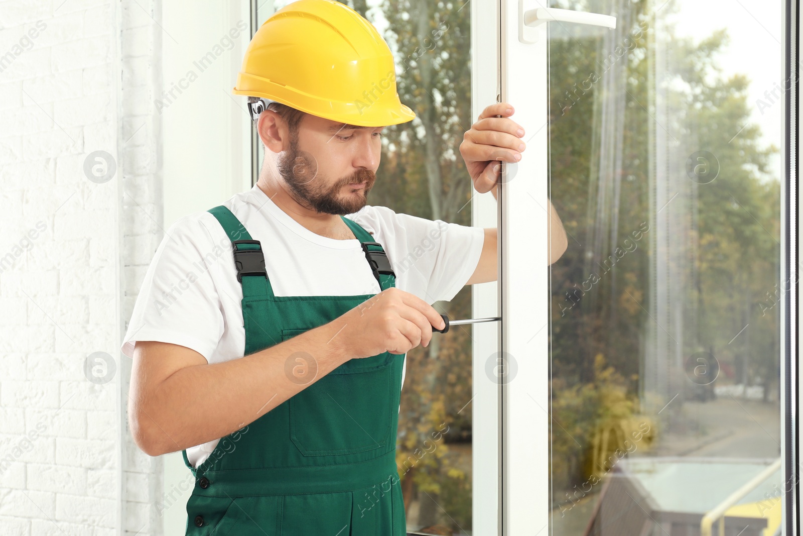 Photo of Construction worker installing new window in house