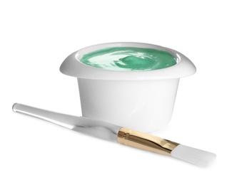 Freshly made spirulina facial mask in bowl and brush on white background