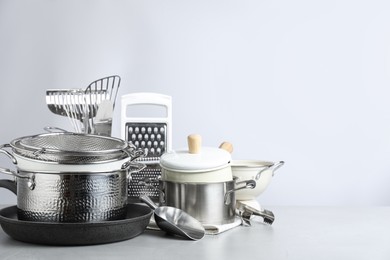 Photo of Set of clean kitchenware on light background. Space for text