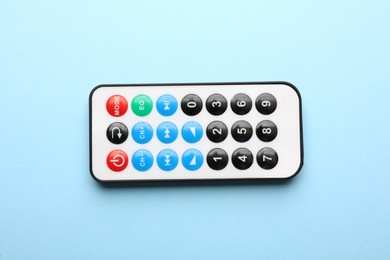 Remote control on light blue background, top view