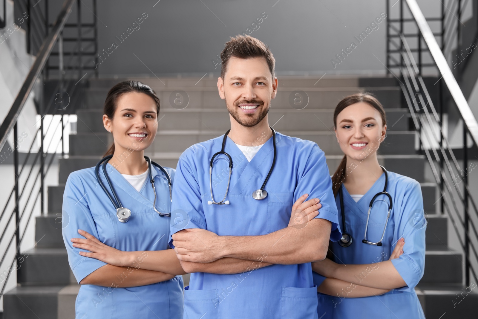 Photo of Team of professional doctors on staircase in clinic