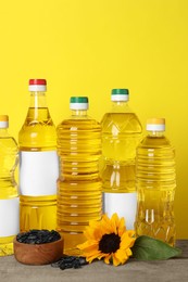 Photo of Bottles of cooking oil, sunflower and seeds on wooden table
