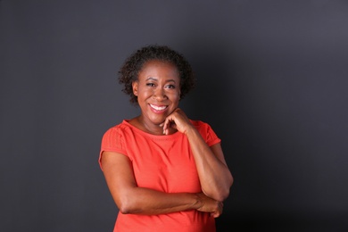 Portrait of happy African-American woman on black background