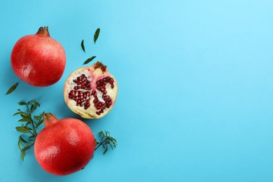 Flat lay composition with ripe pomegranates on light blue background. Space for text