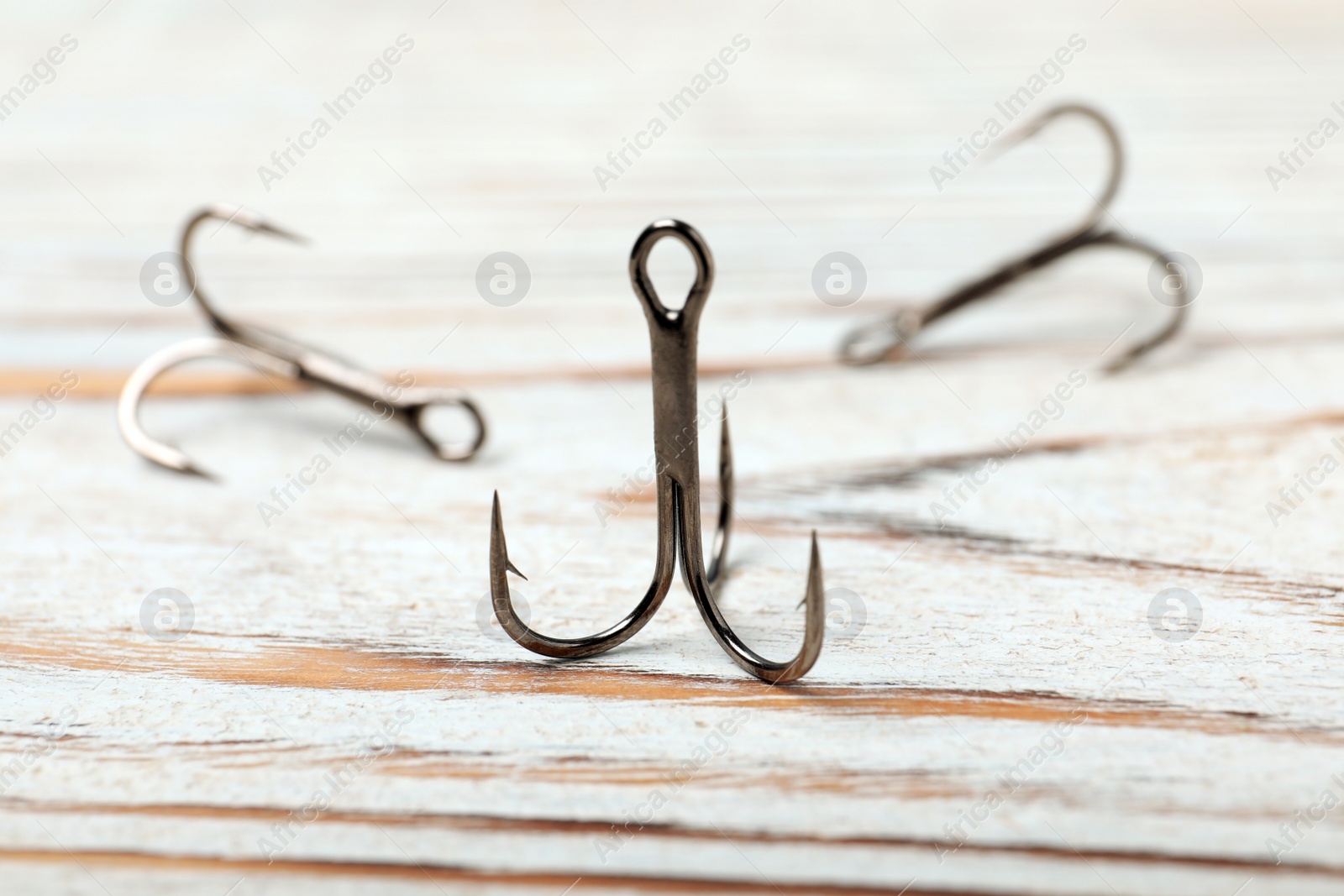 Photo of Fishing hooks on wooden table. Angling equipment