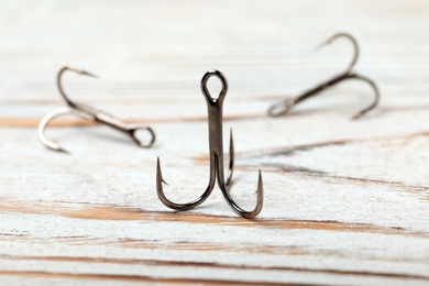 Photo of Fishing hooks on wooden table. Angling equipment