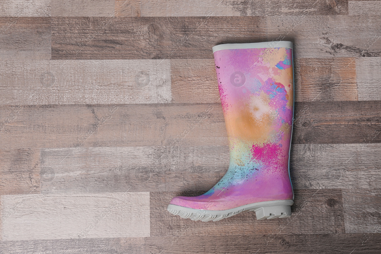 Photo of Gumboot on wooden background, top view. Female shoes