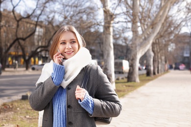 Photo of Portrait of happy young woman talking on phone outdoors